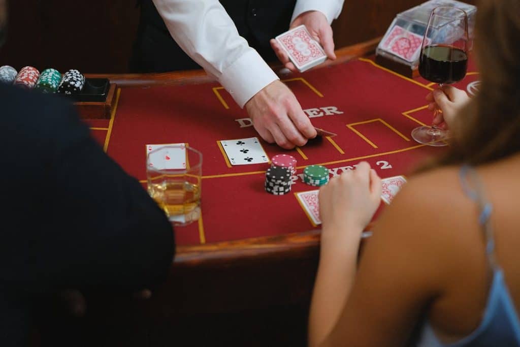 Free A dynamic scene at a casino card table with players engaged in a game featuring poker chips and drinks. Stock Photo