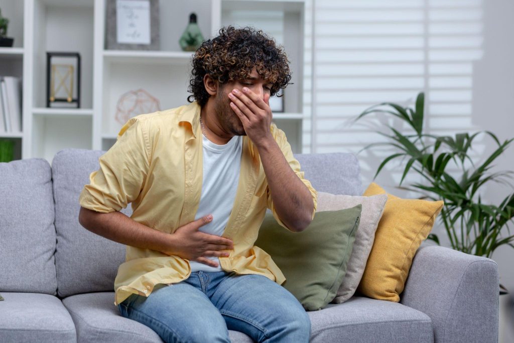 A young person having nausea, wondering what essential oils help with nausea.