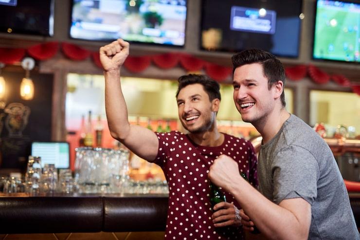 Excited men watching american football competition