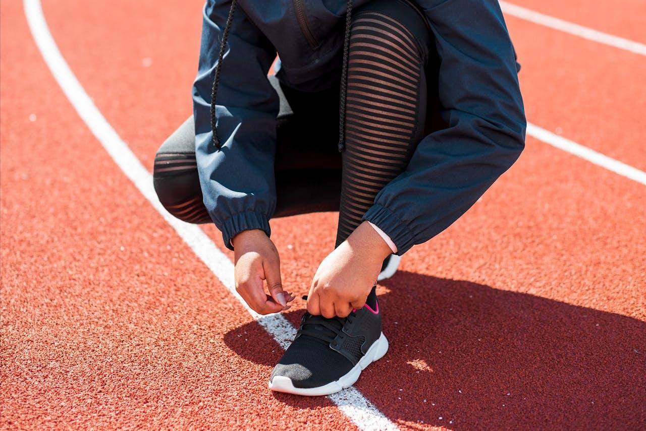 Woman tying her shoelaces before running.