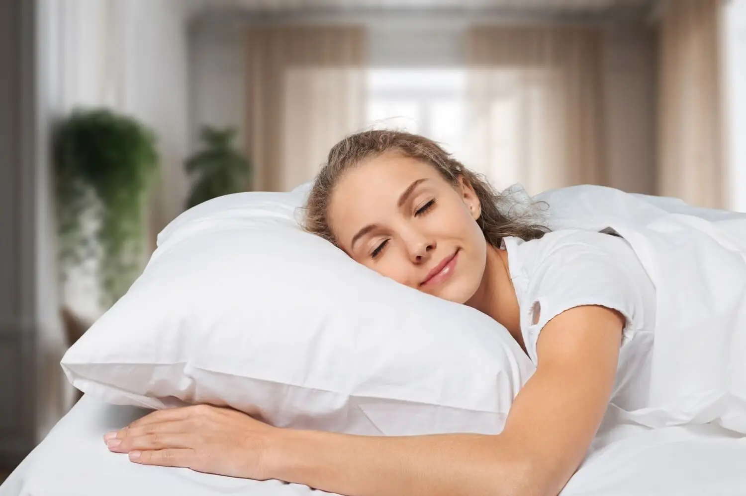Woman peacefully sleeping on white pillow in bright, modern bedroom