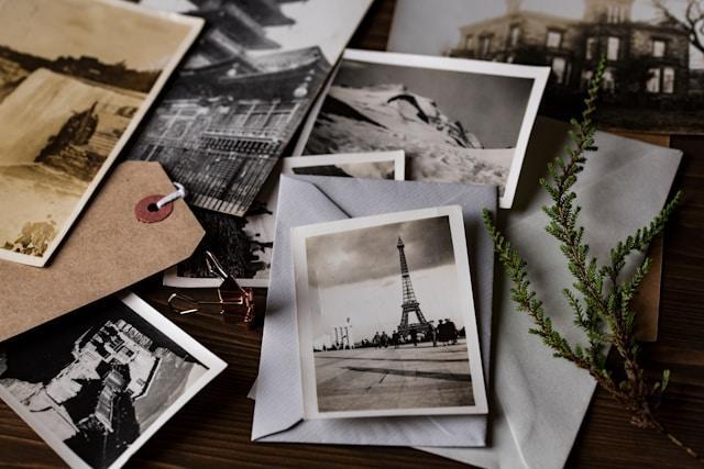 Various vintage, black and white photographs on a wooden surface.