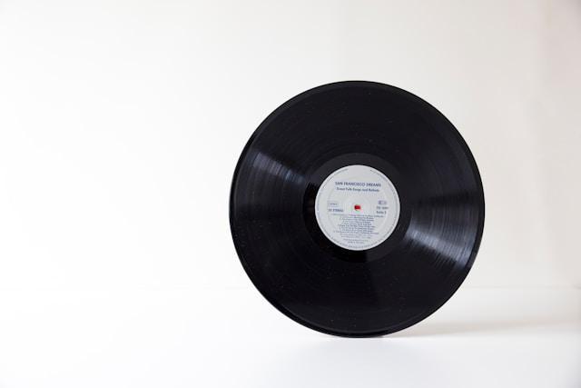 A vinyl record standing on a white surface.