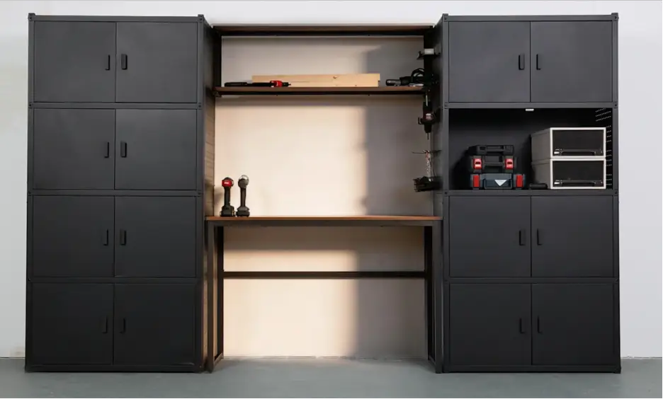 Modern garage workspace with black metal storage cabinets and tools on wooden shelves