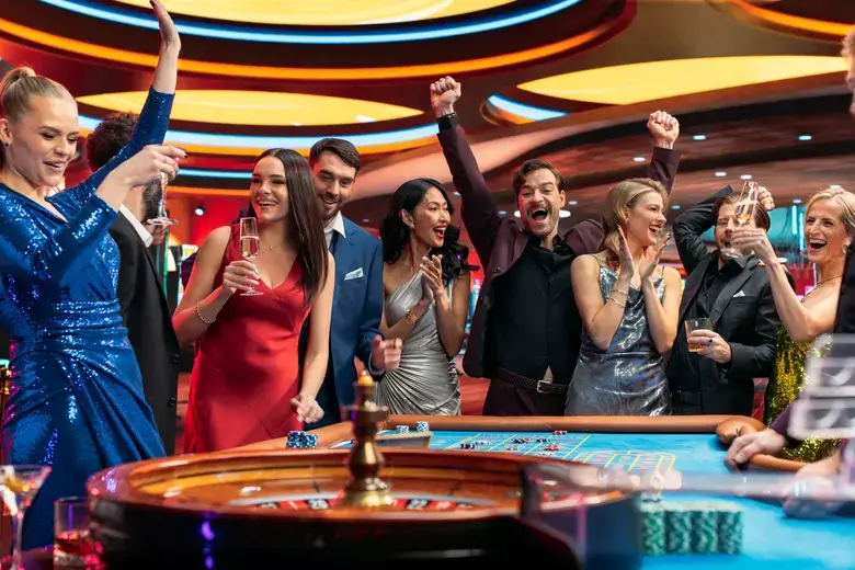 Group of people celebrating around a roulette table in an upscale casino setting