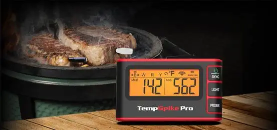 Steaks grilling on a ceramic grill with TempSpike Pro thermometer displaying temperature