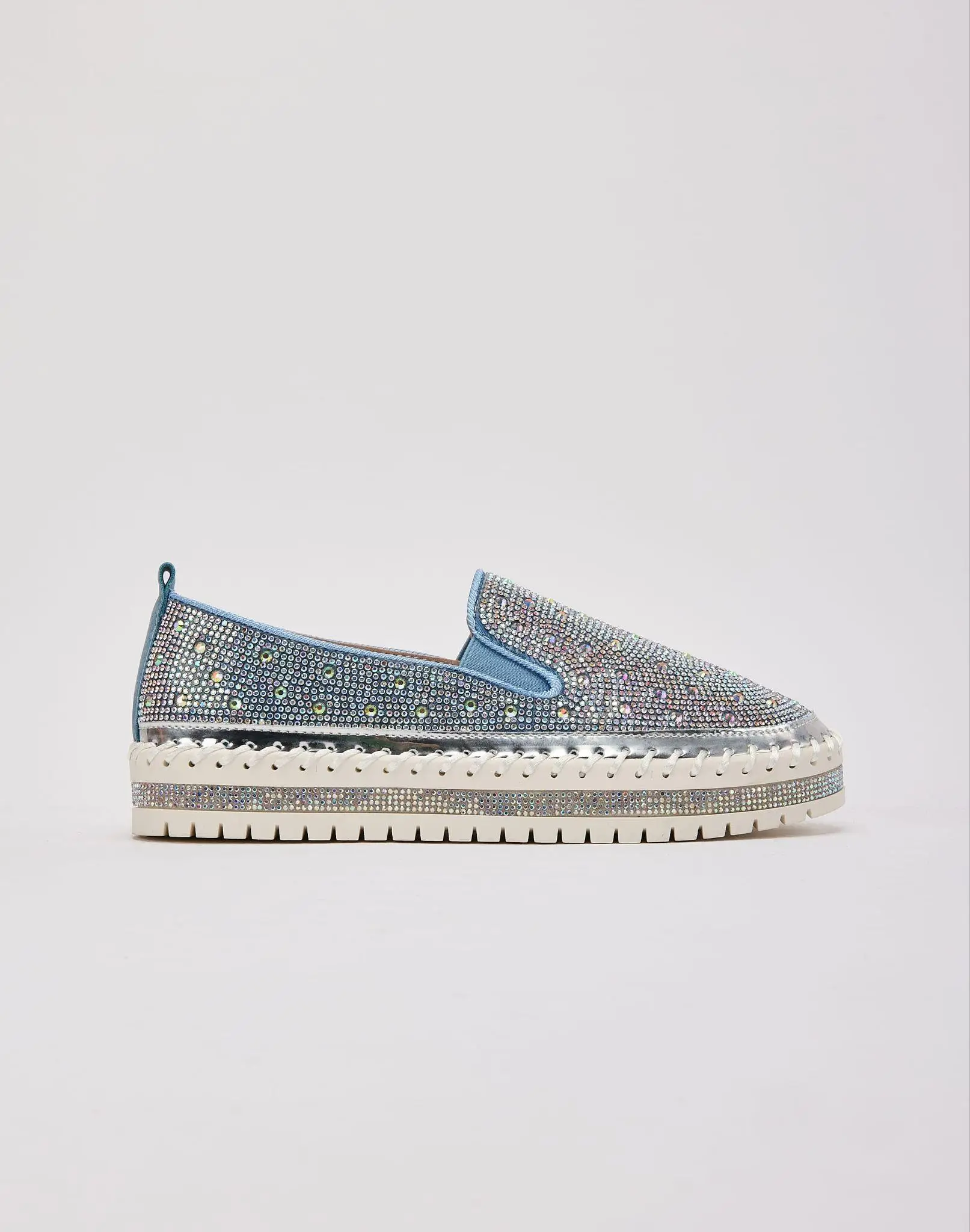 Sparkling slip-on shoe with rhinestones and thick white sole against plain background