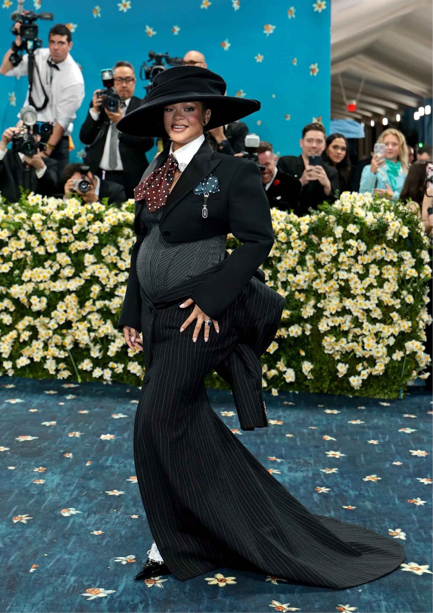 Rihanna at the 2025 Met Gala in a Marc Jacobs pinstripe suit revealing her third pregnancy.
