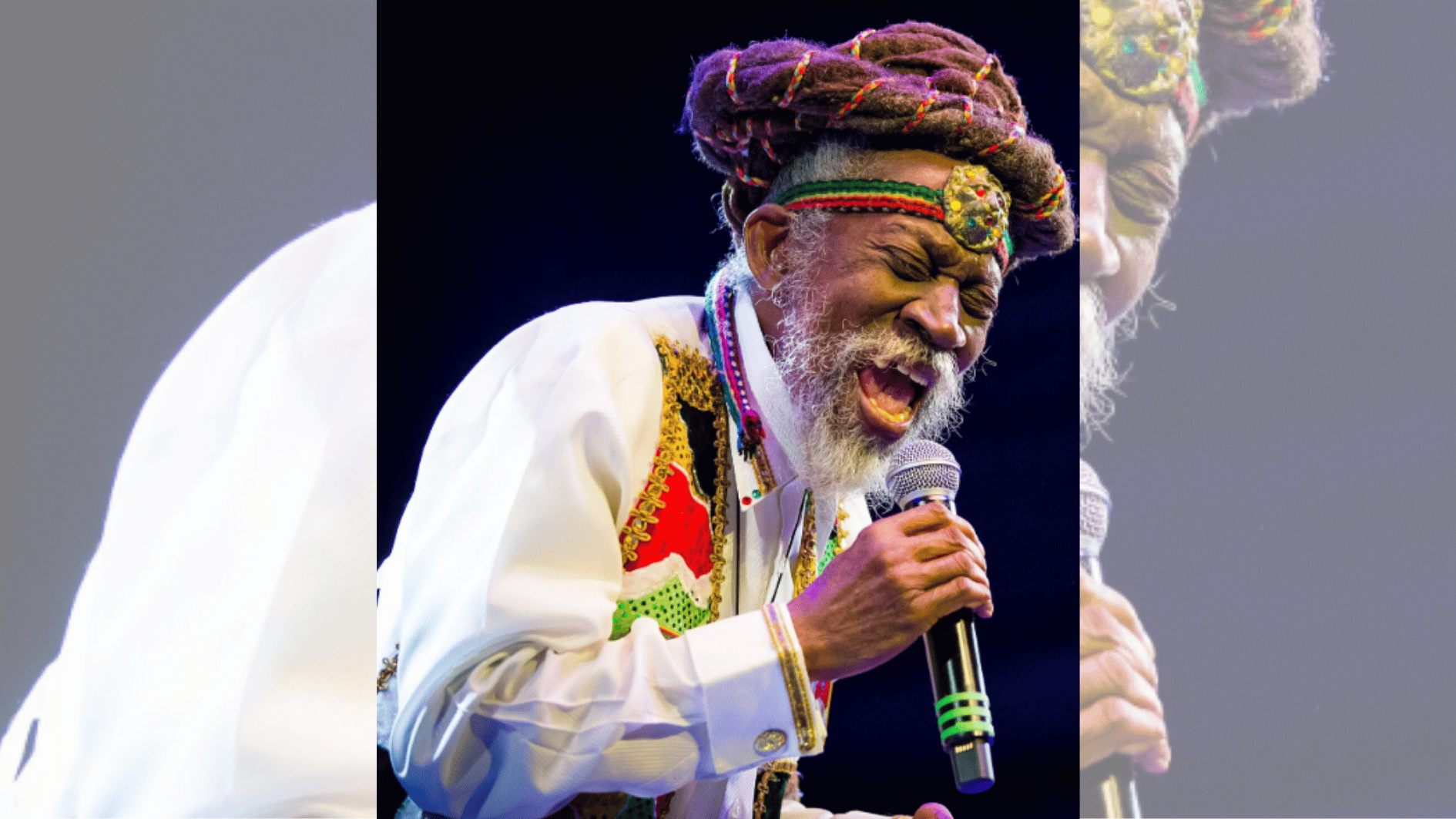 elderly singer with gray beard and colorful headband passionately singing into microphone