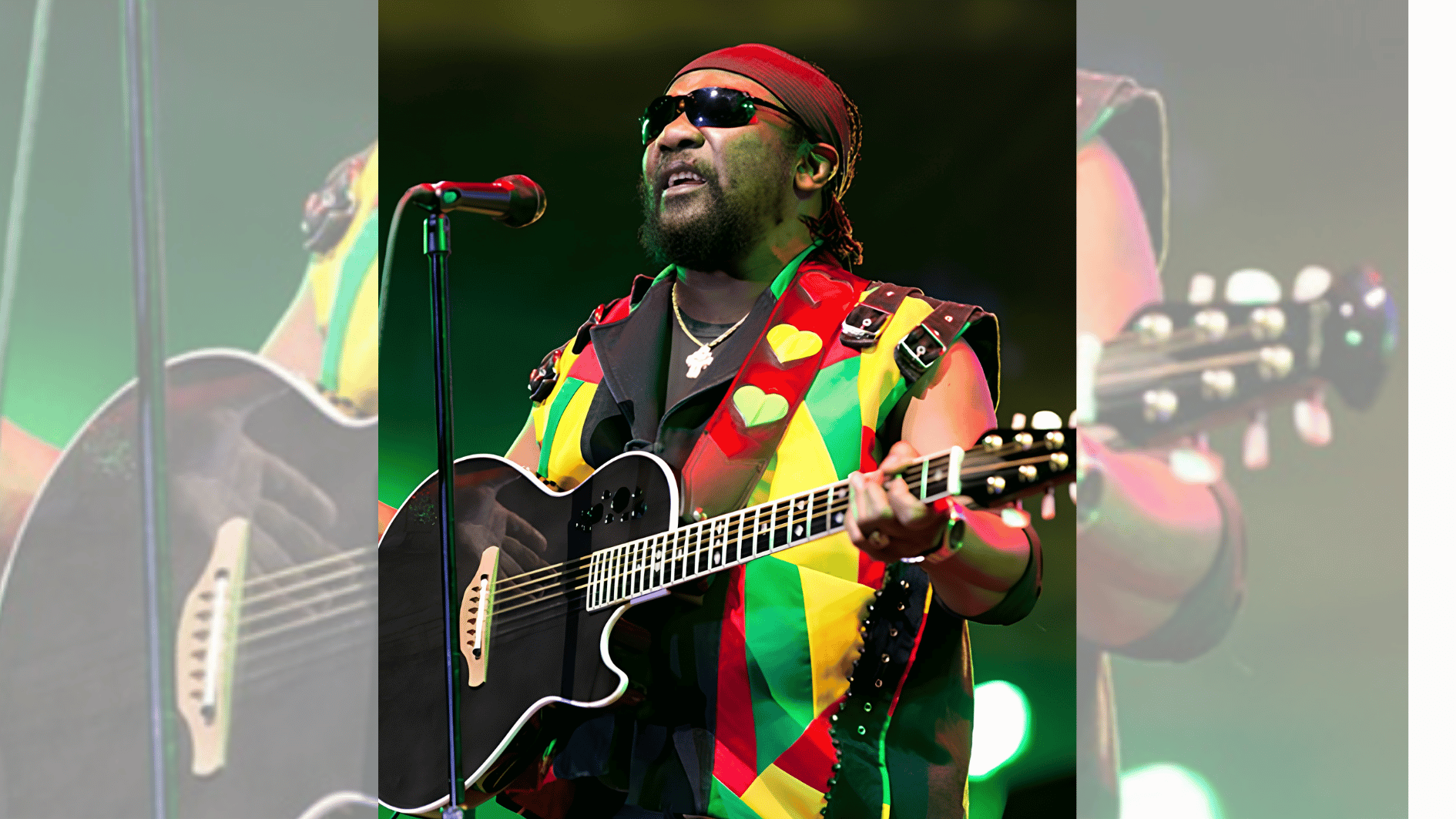 musician in colorful red, yellow, and green vest performing live with black guitar.