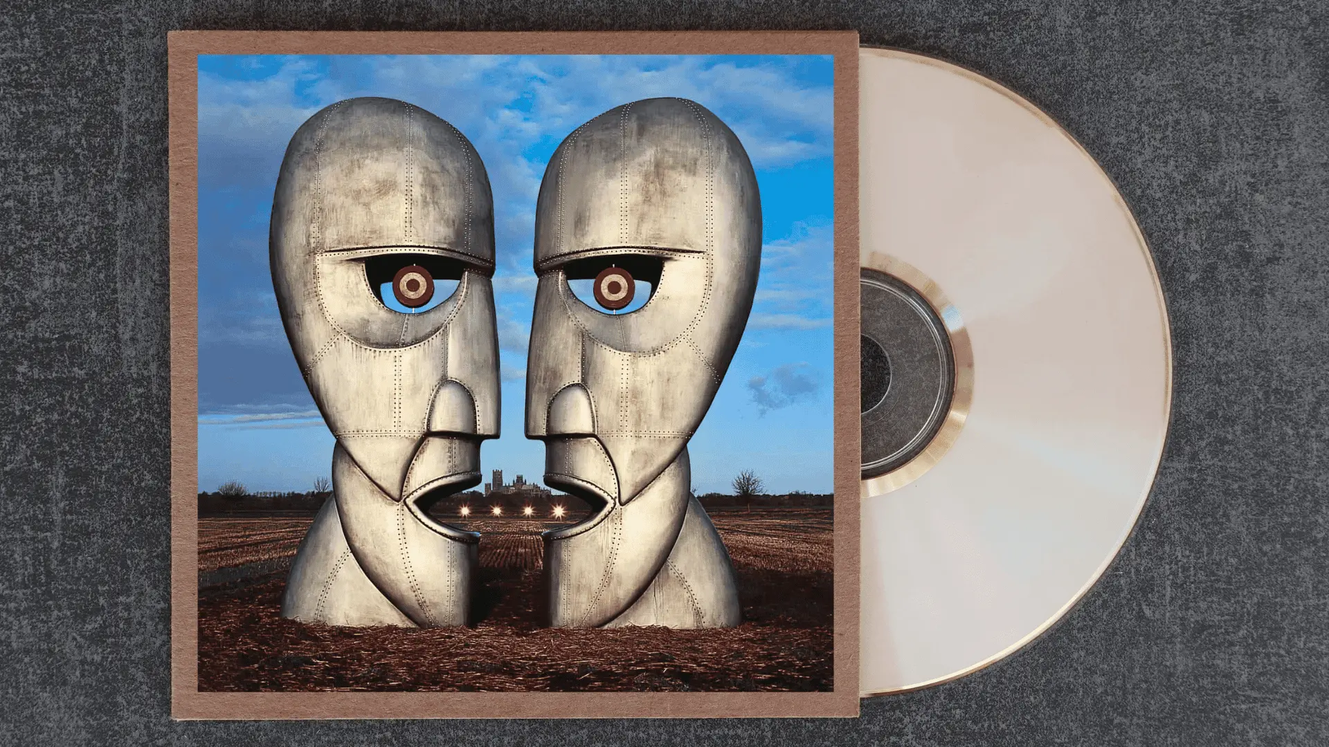 pink floyd the division bell album cover featuring two large metallic heads facing each other in an open field