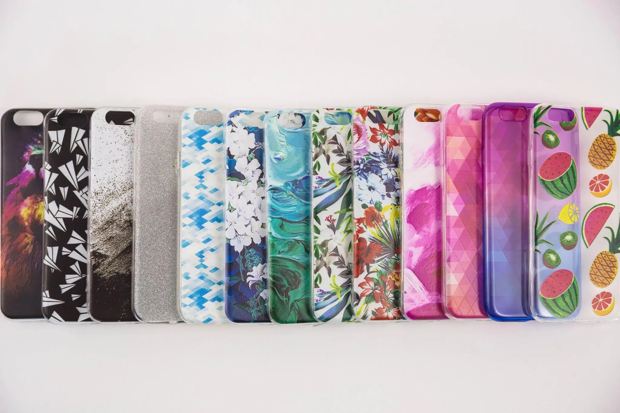 Assorted colorful smartphone cases with various patterns and designs on a white background