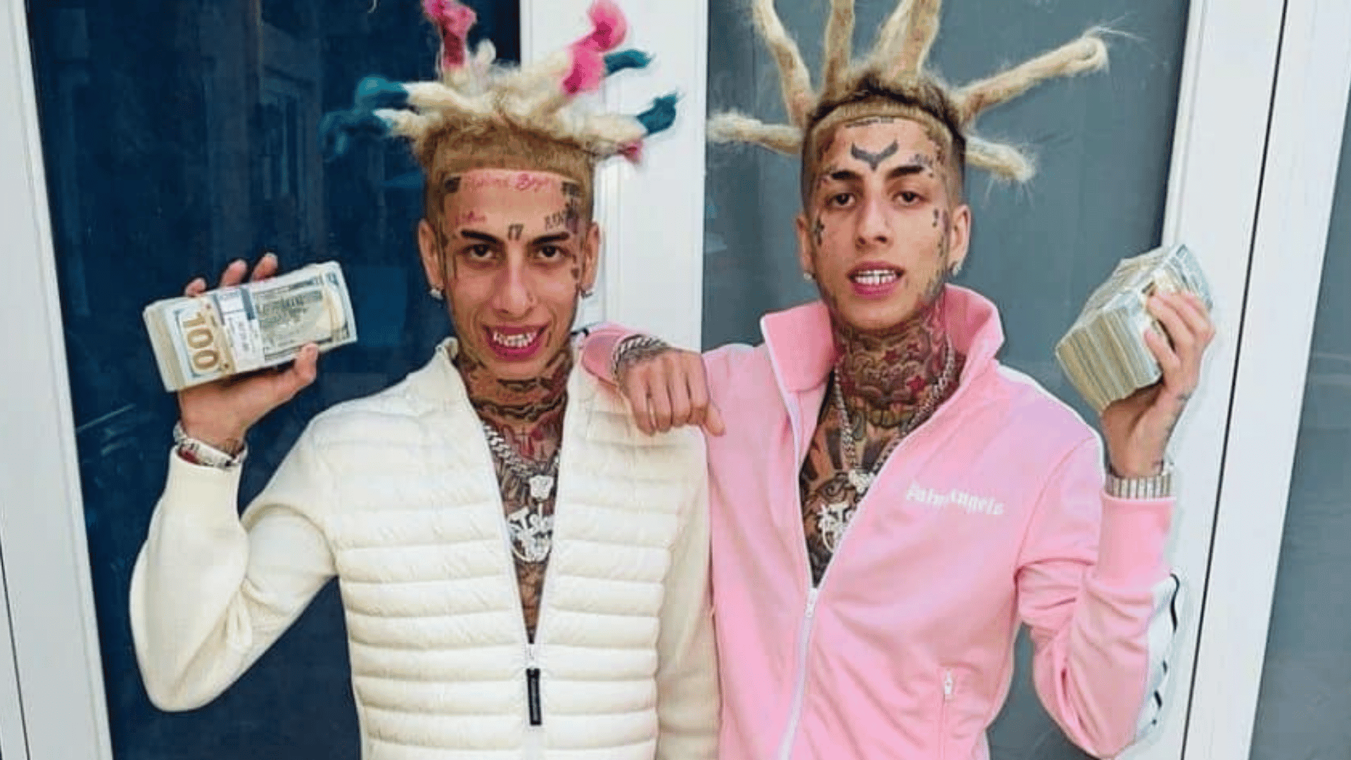 Island Boys Flyysoulja and Kodiyakredd holding cash stacks in designer tracksuits
