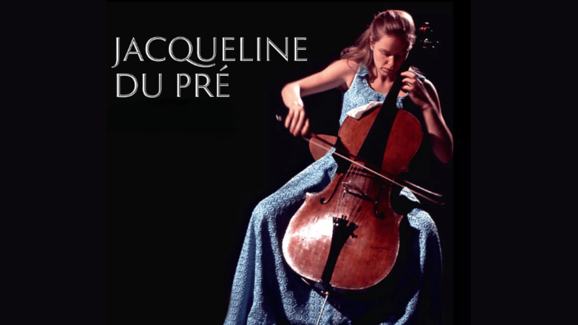 Jacqueline du Pré playing cello passionately during a live classical music performance with orchestra background.