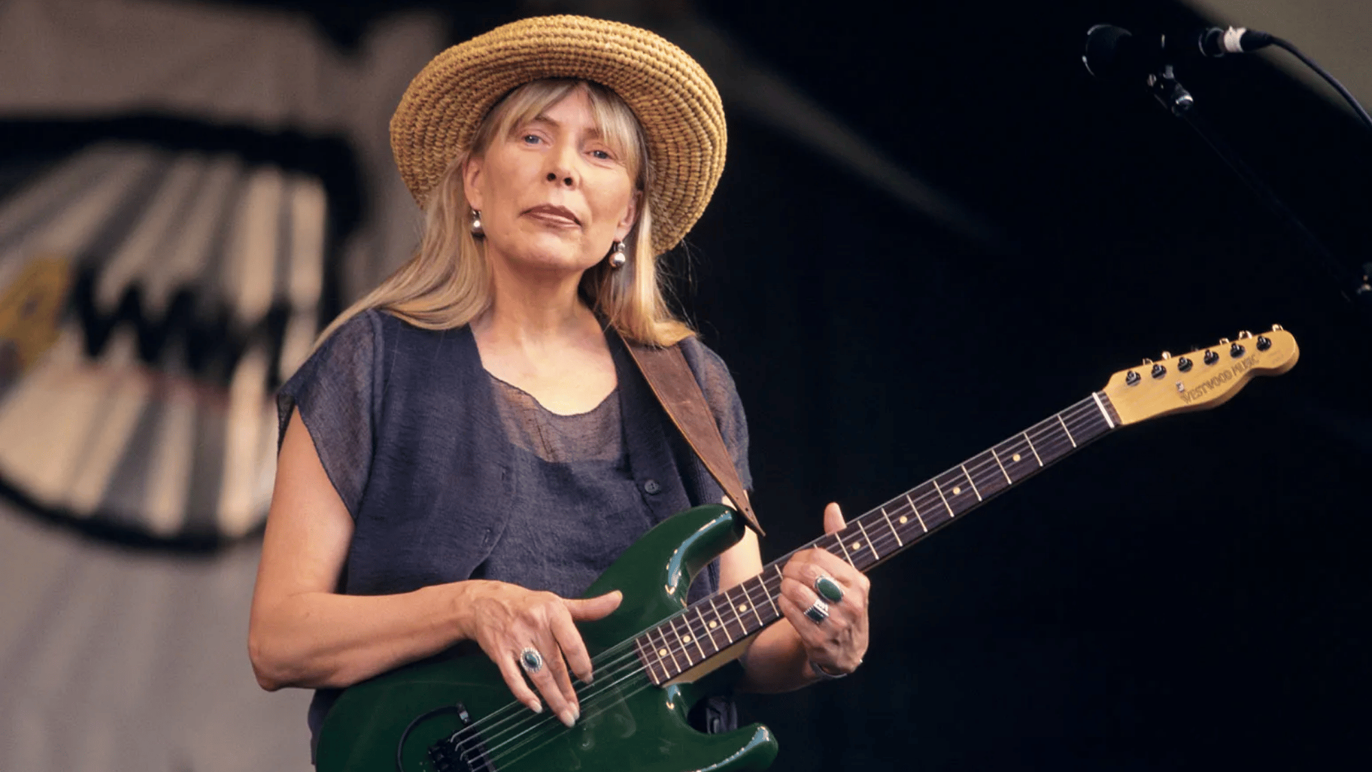 Joni Mitchell performing during a live show, linked to her music royalties