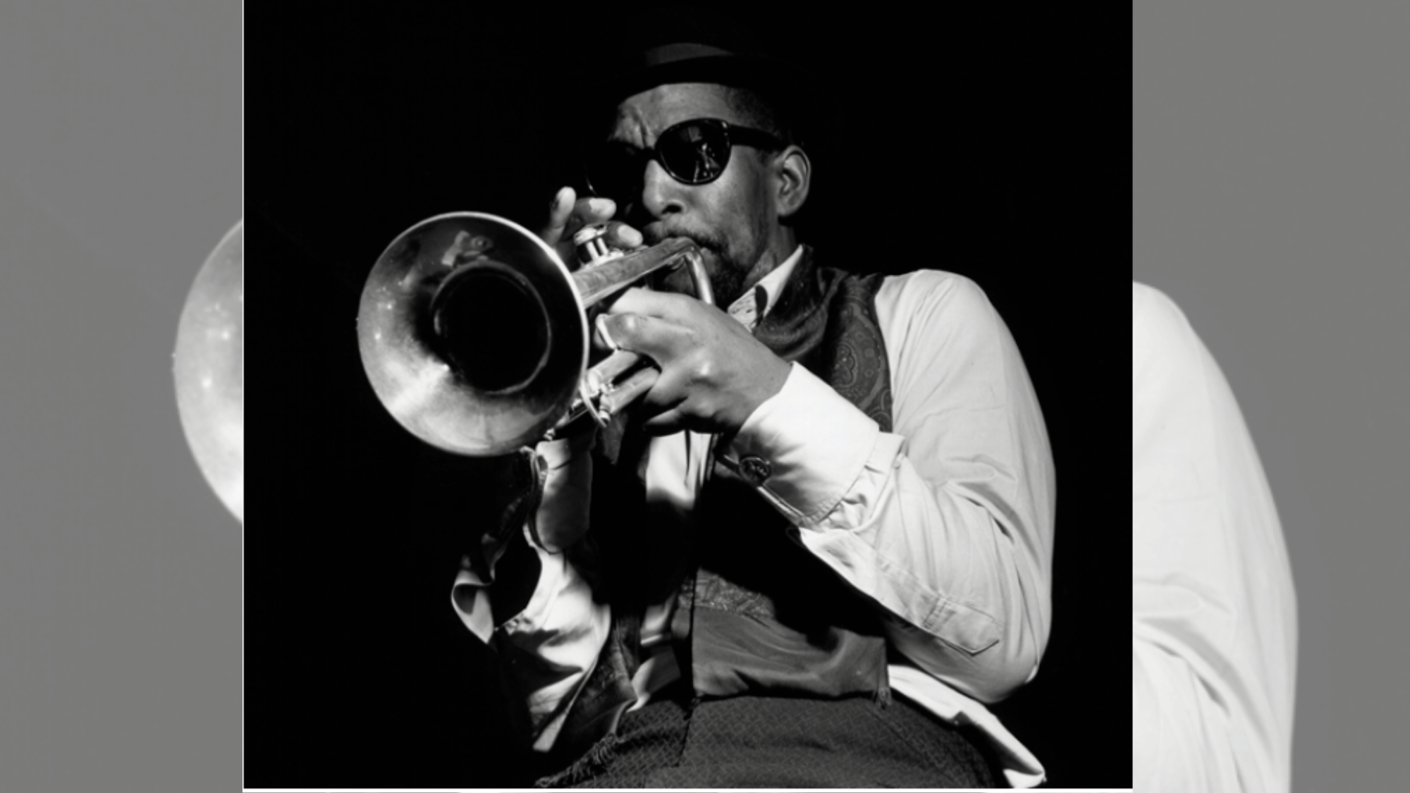 kenny dorham playing trumpet in sunglasses during a moody jazz club performance
