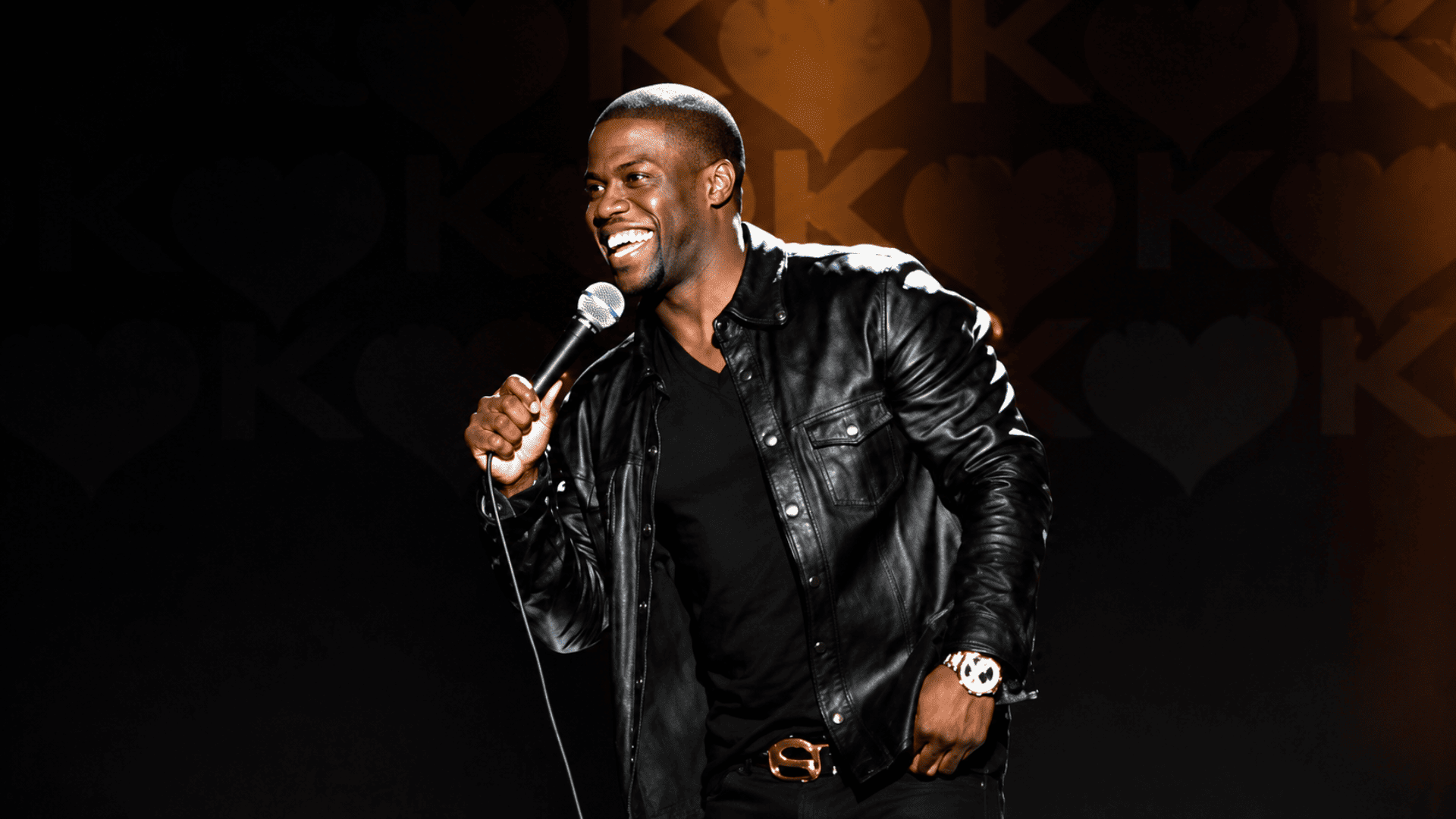 kevin hart performing stand up comedy on stage in front of a live audience during a comedy show