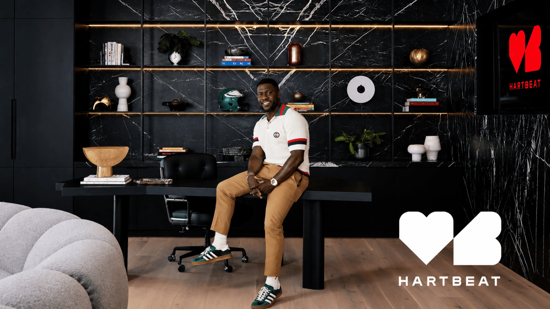 kevin hart sitting in the hartbeat office surrounded by modern decor and branded workspace elements