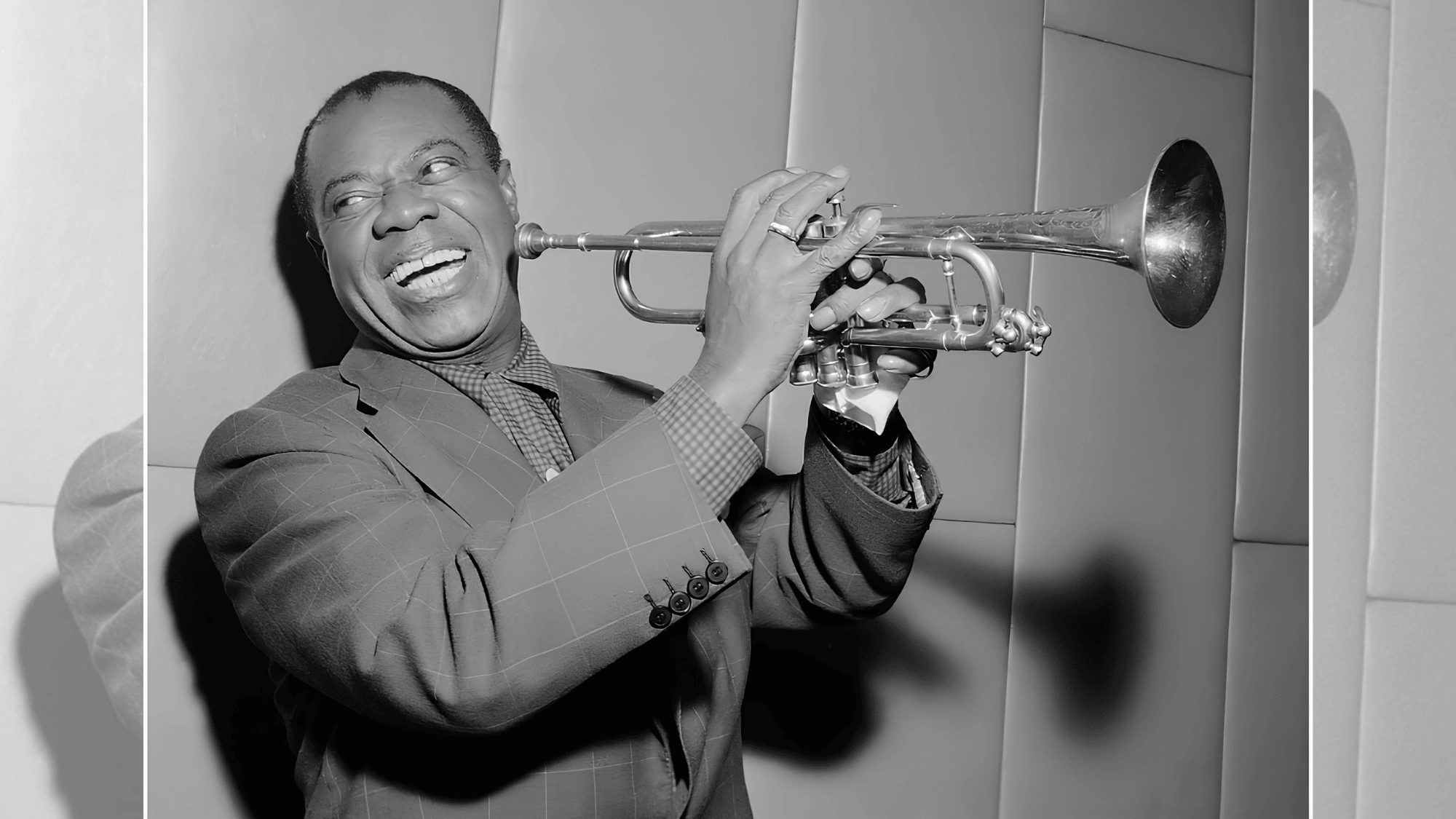 louis armstrong smiling while playing trumpet during a classic jazz studio session