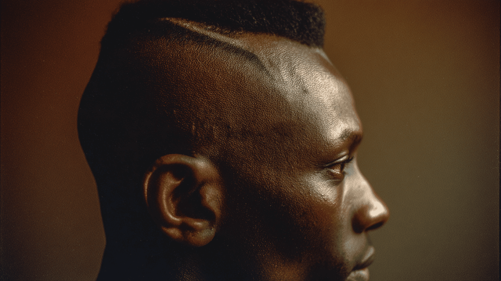 Mid fade black men mohawk strip textured bald sides sharp edges temple fade portrait