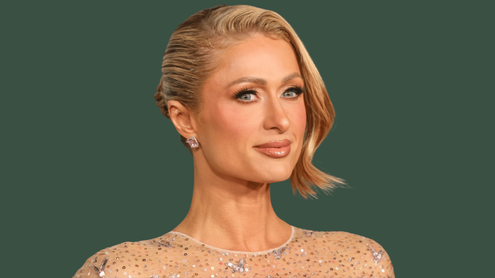 A close-up shot of Paris Hilton against a forest green background