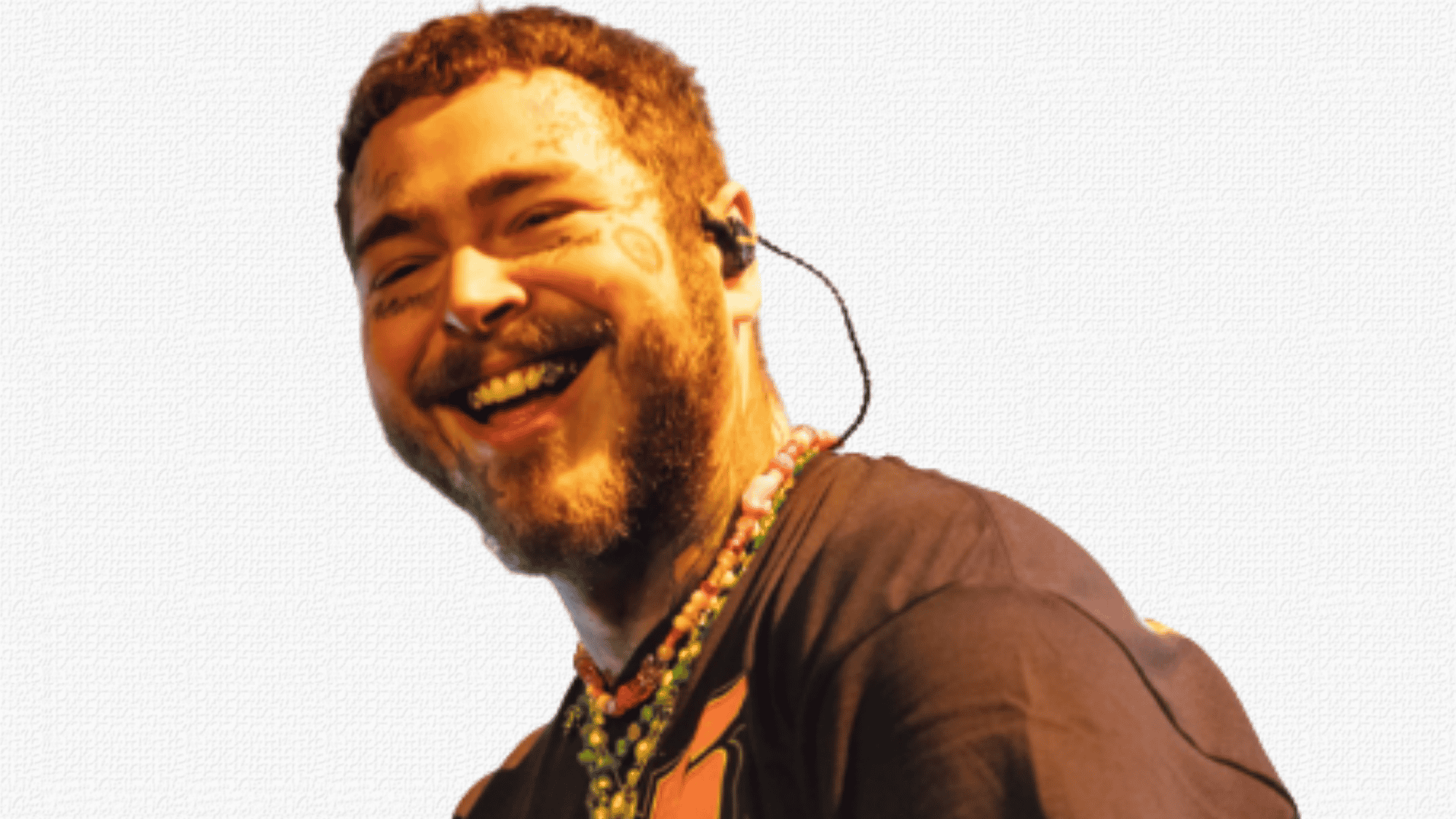 Post Malone laughing on stage wearing black shirt and colorful beaded necklaces