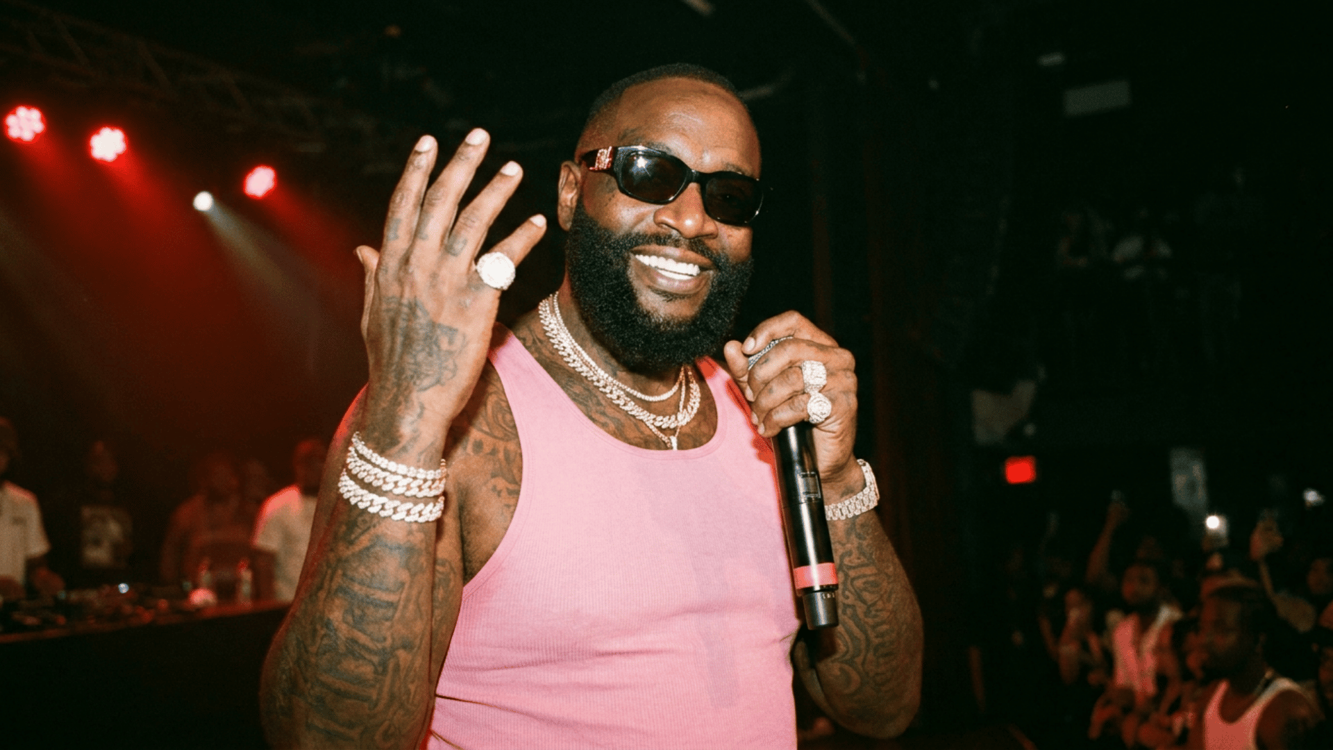 Male rapper singing into mic under stage lights during concert