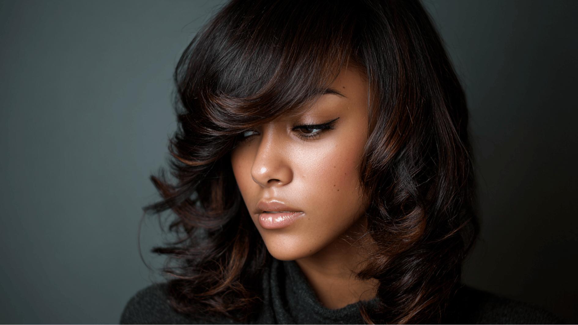 sew-in with side-swept bangs creating a soft elegant look