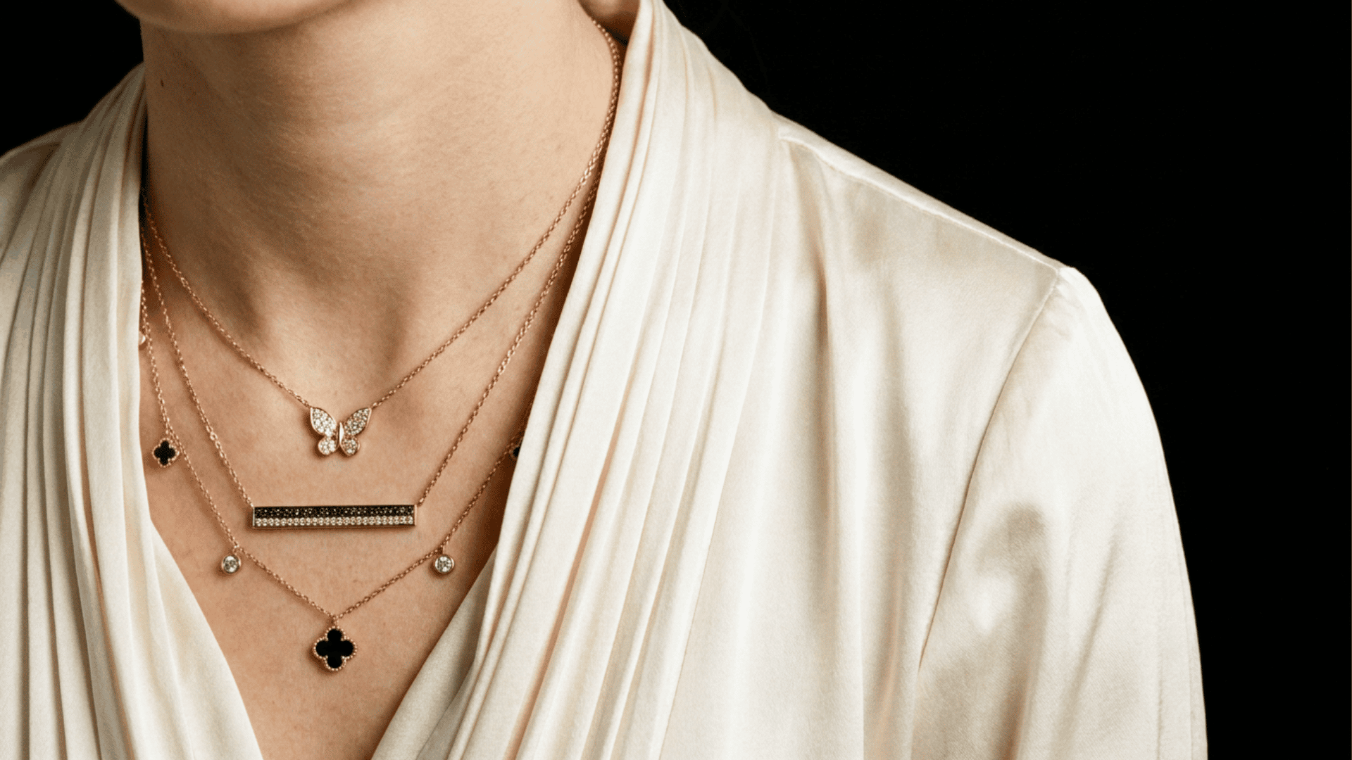 Close-up of layered silver and gold necklaces stacked at varying lengths for a trendy everyday jewelry look