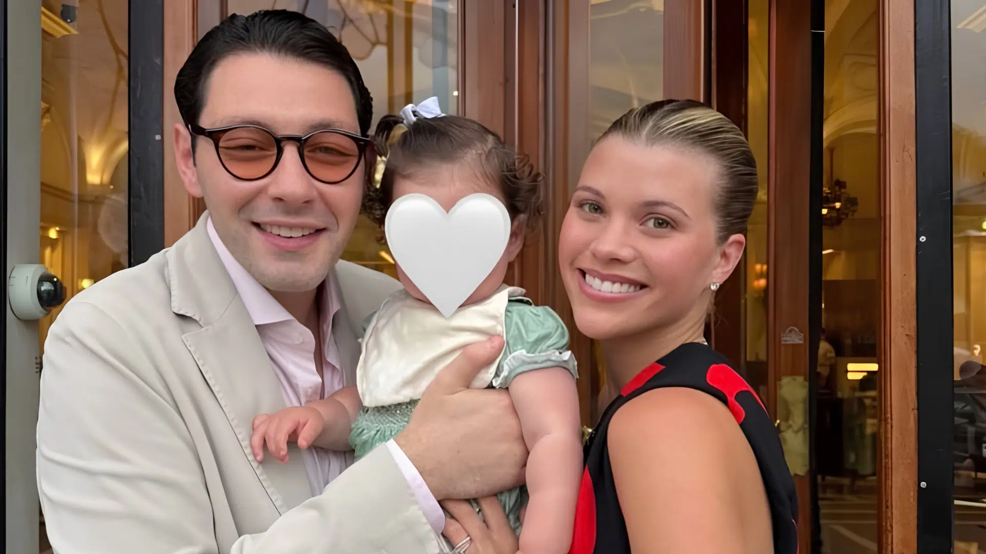 sofia richie grainge and her husband elliot posing together while holding their baby daughter eloise