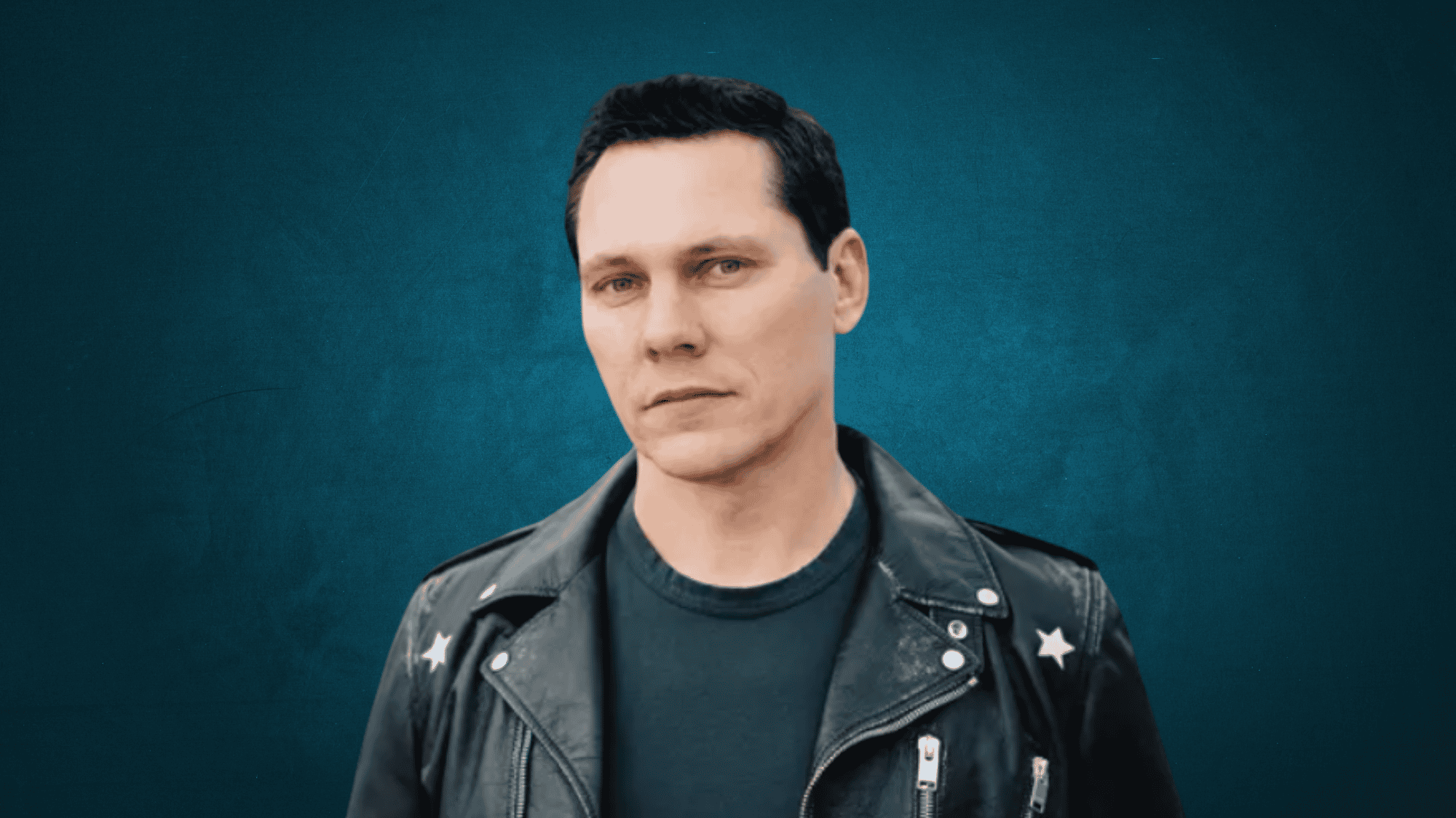 Tiësto performing at a major electronic music festival representing over two decades as a global DJ superstar.