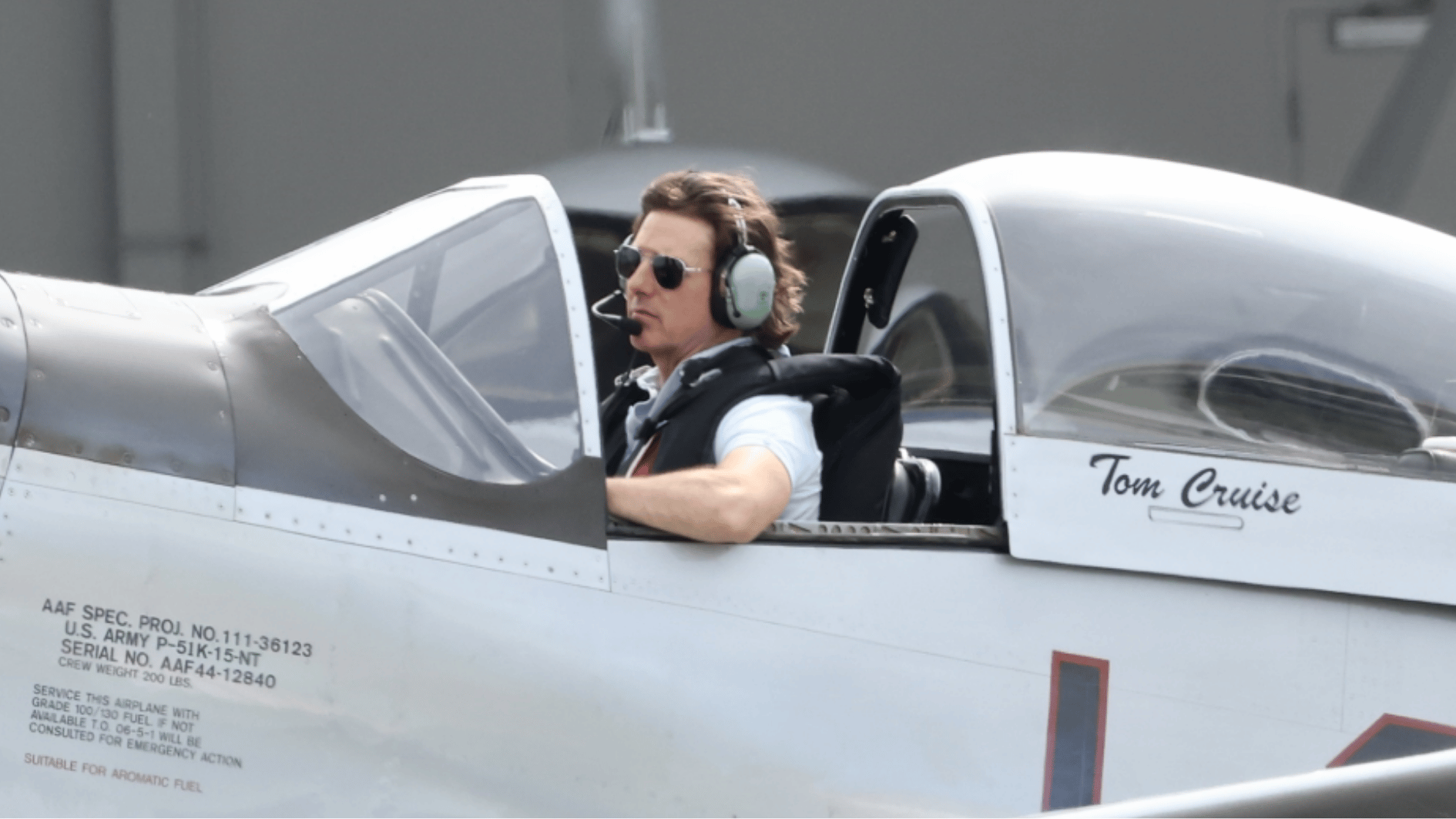 tom cruise seated in a personal aircraft cockpit wearing a headset and sunglasses during flight preparation