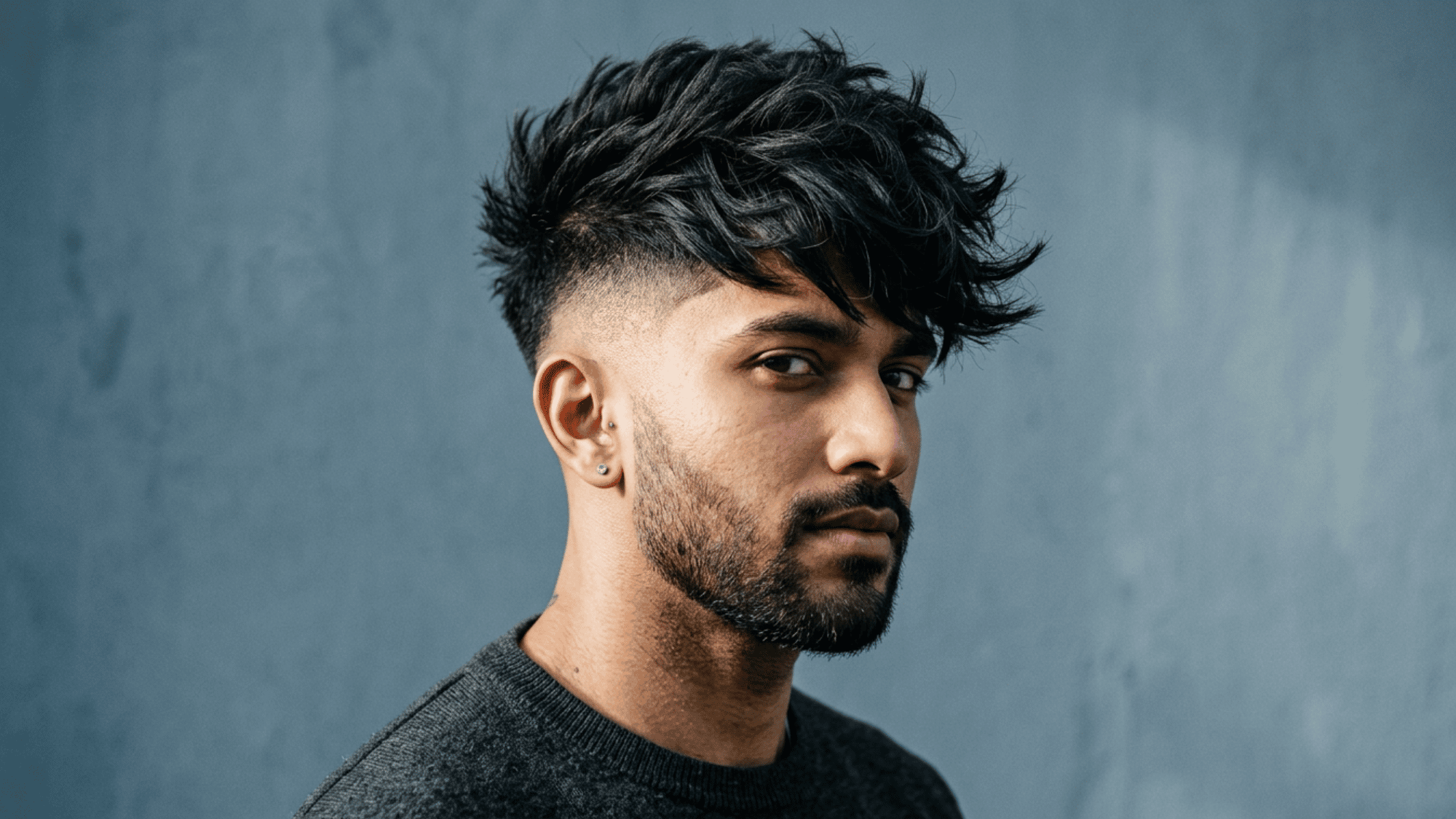 Man with oblong face showing undercut with voluminous textured top and beard