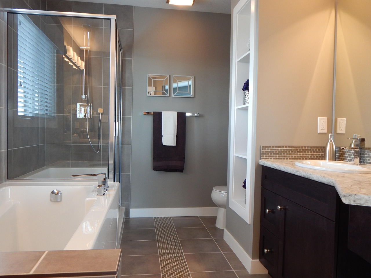 A modern bathroom with contemporary silver fixtures and dark wooden cabinets.