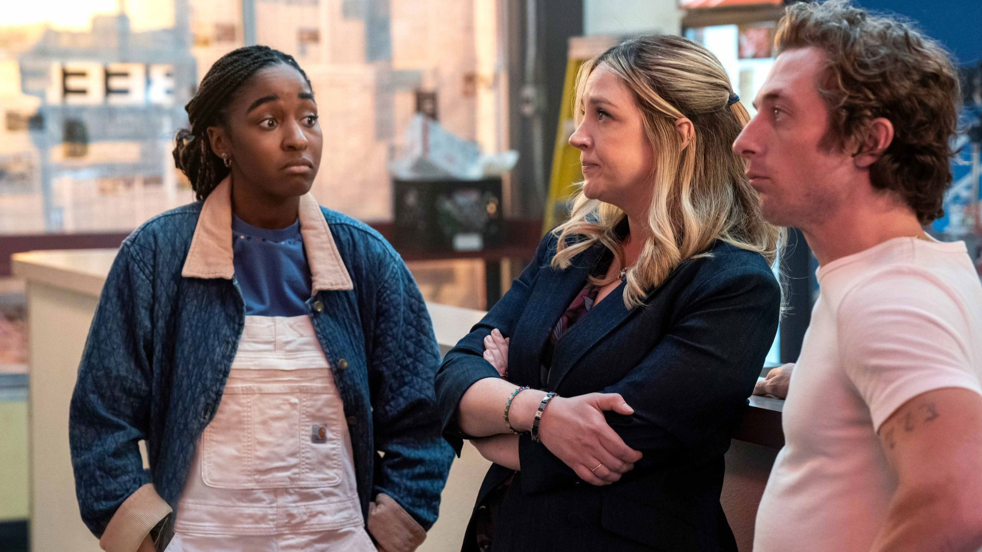 three characters having a tense conversation inside the restaurant