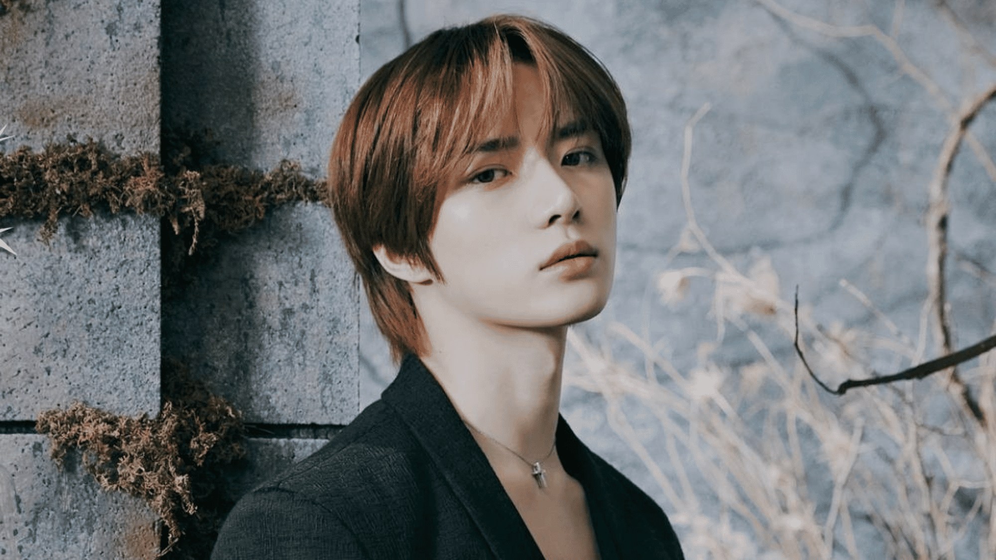 a man posing near a stone wall during a concept photoshoot