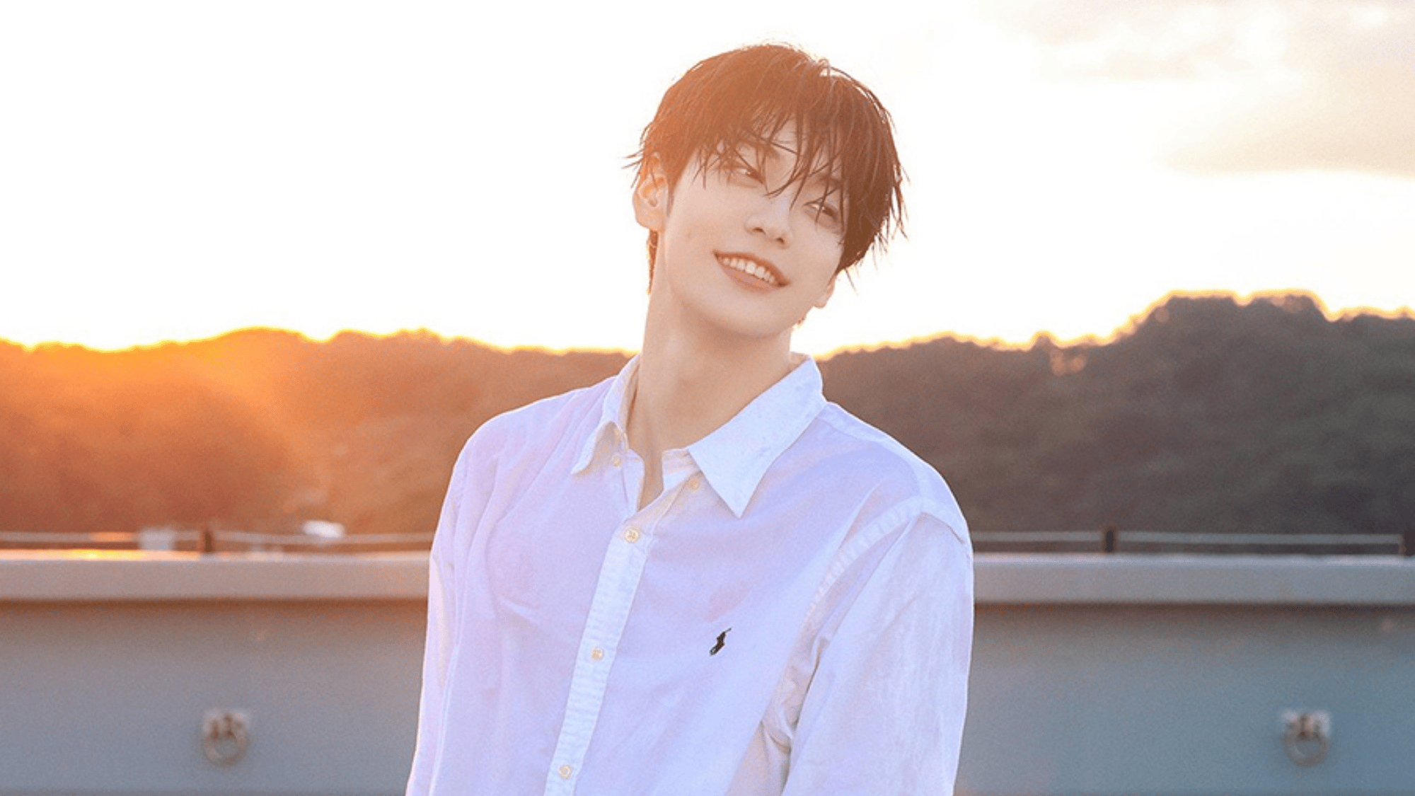 a man smiling in a white shirt during a sunset outdoor photoshoot