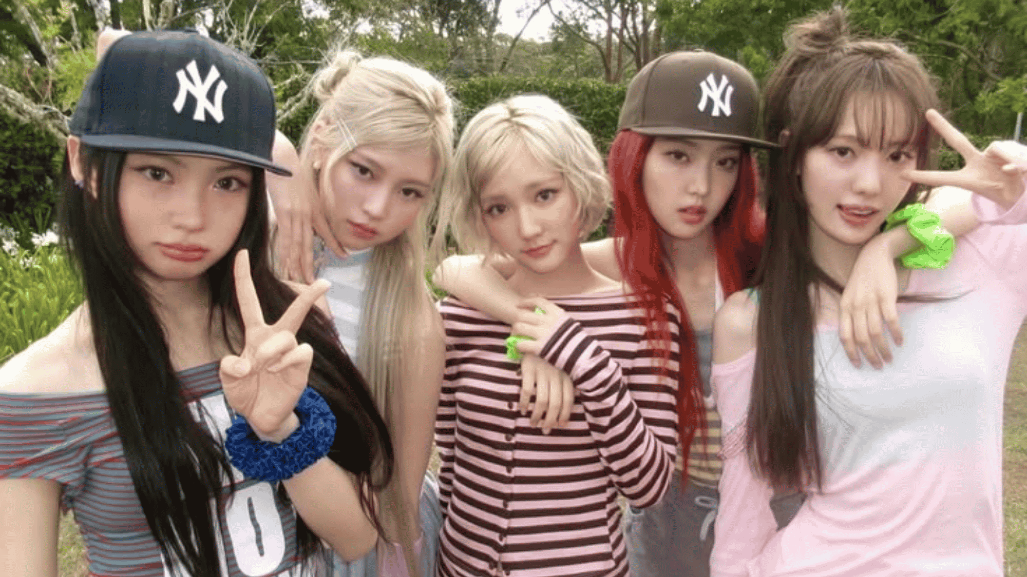 All five KiiiKiii members in casual striped outfits throwing peace signs