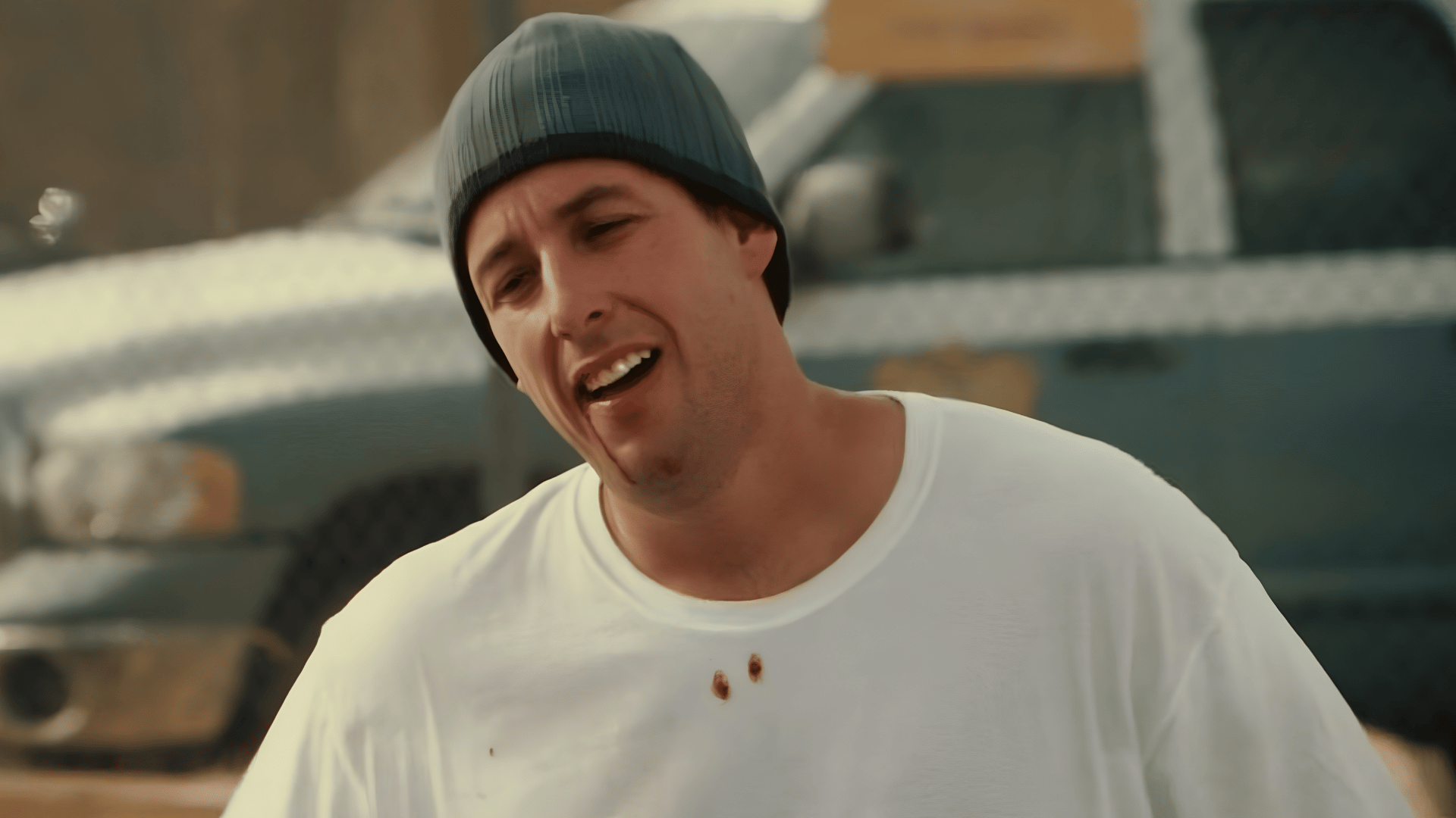 Man in gray beanie and oversized white t-shirt outdoors