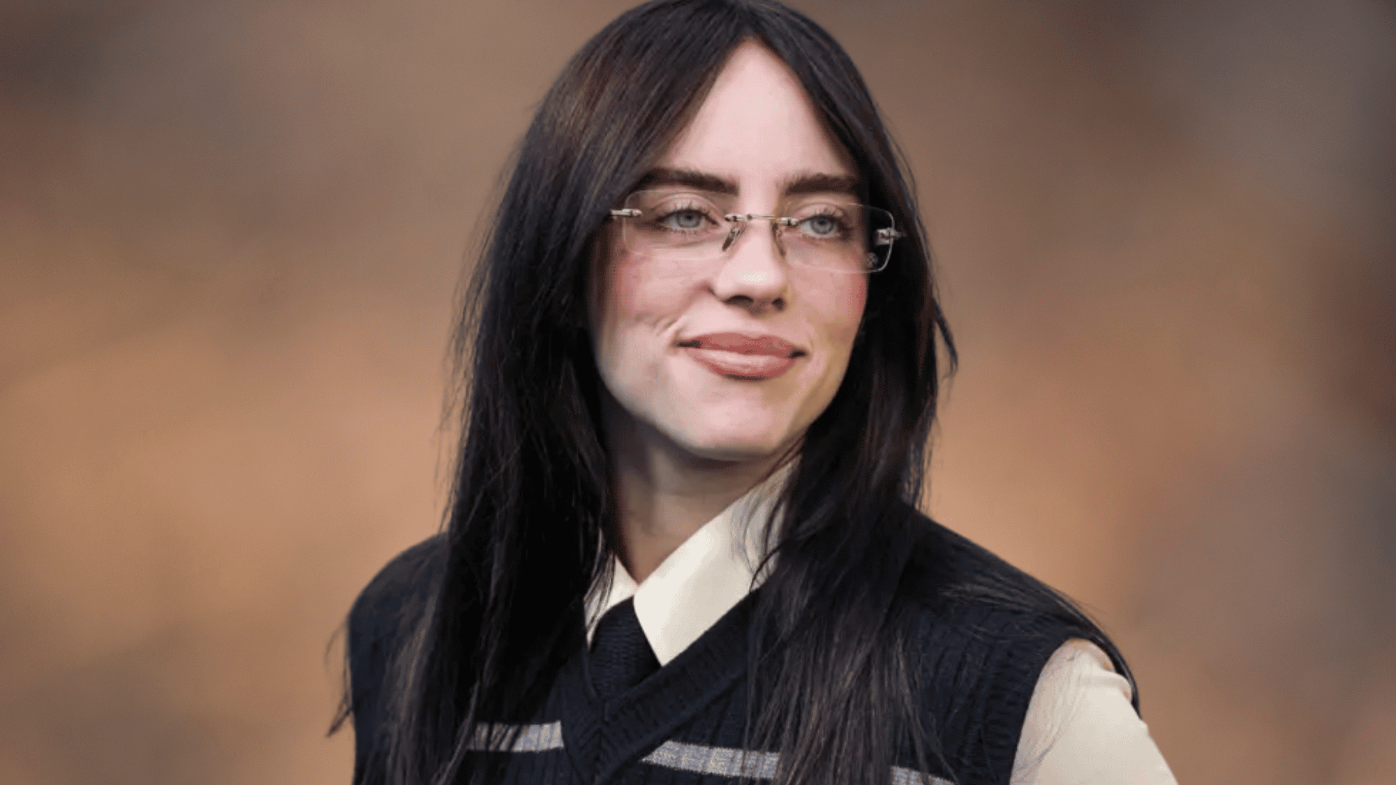 Billie Eilish wearing rimless glasses and a dark vest against a warm brown background