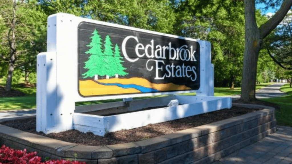 cedarbrook estates community entrance sign surrounded by trees and landscaped greenery in white lake michigan