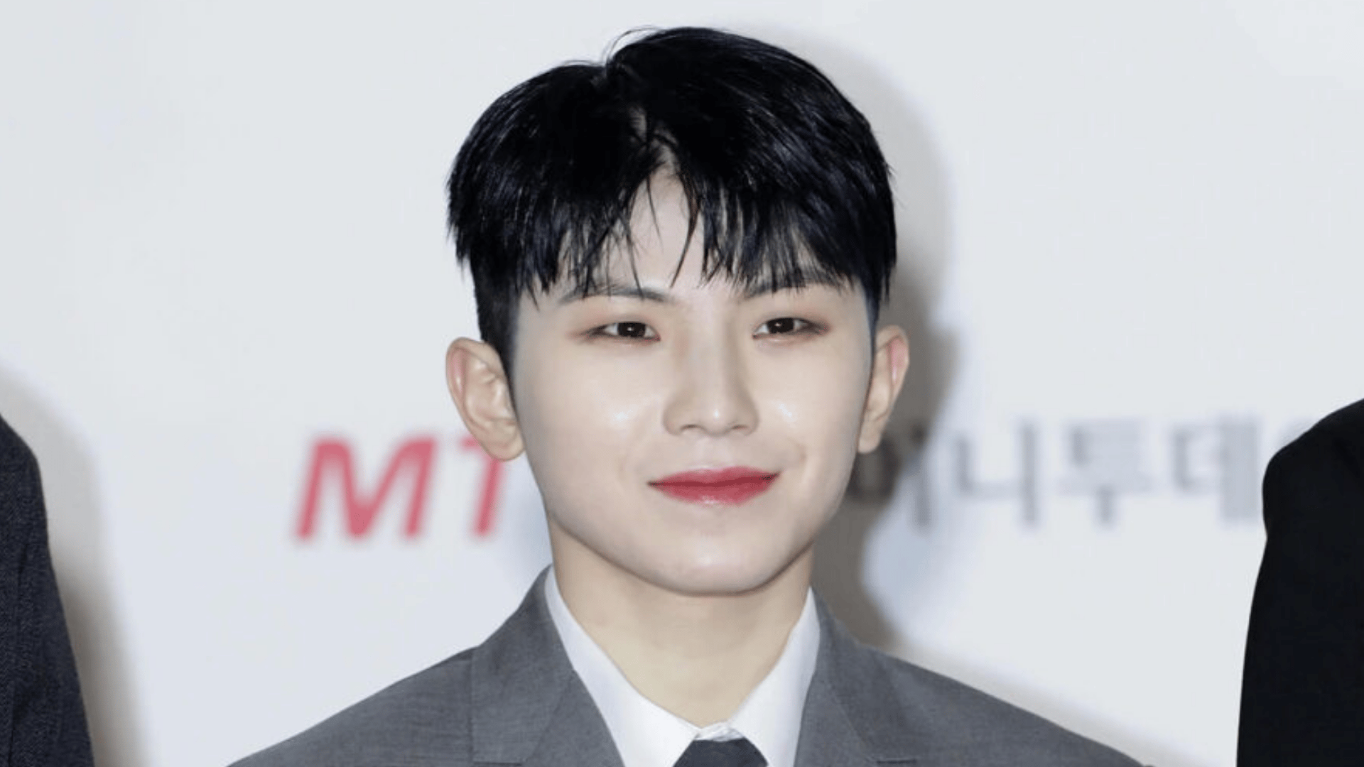 DK of seventeen smiling in a portrait photo showcasing his bright personality