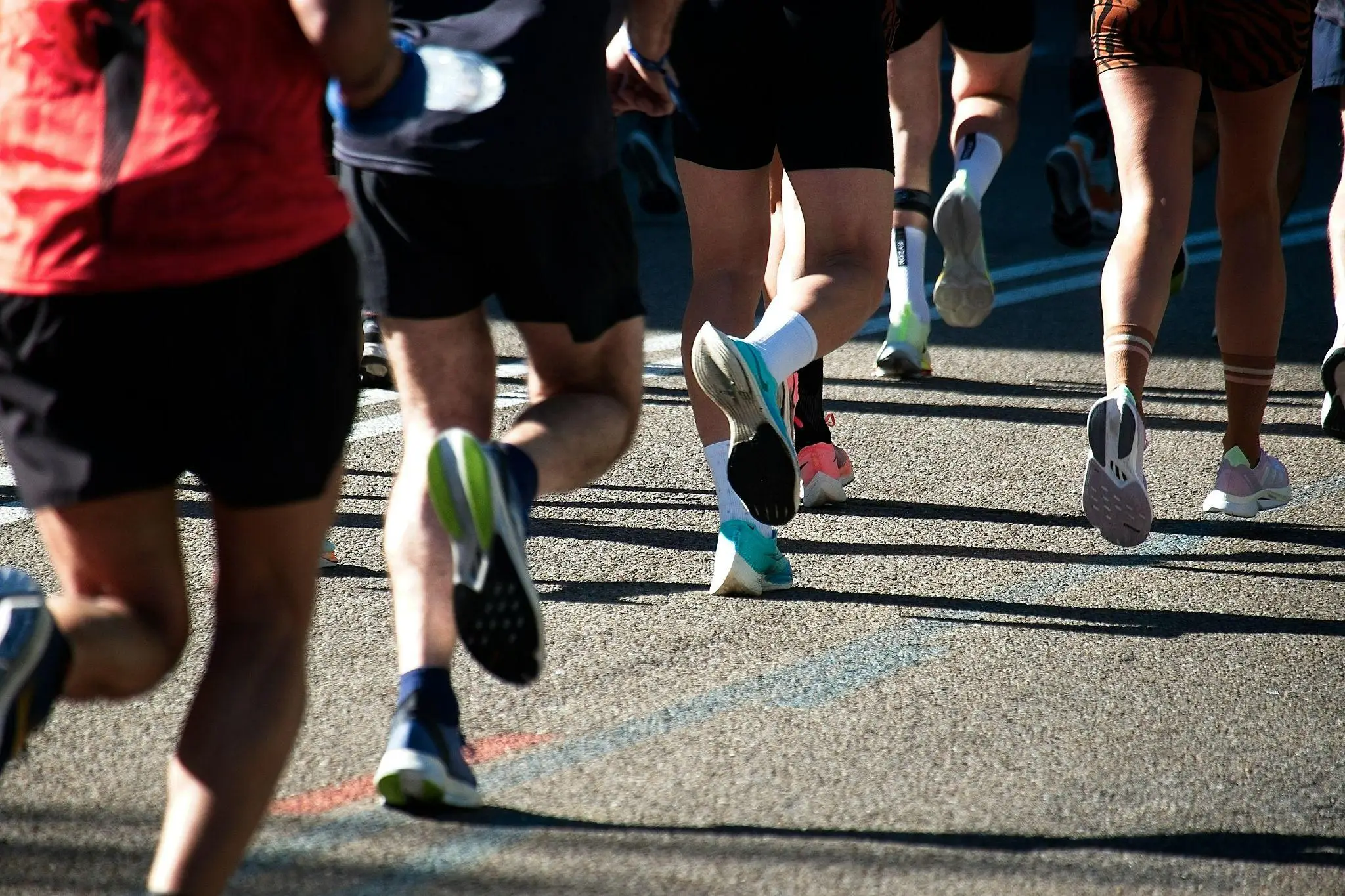 Runners' legs in athletic shoes on an outdoor road during a race