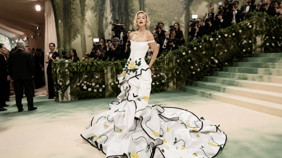 gigi hadid in white floral gown posing on met gala staircase