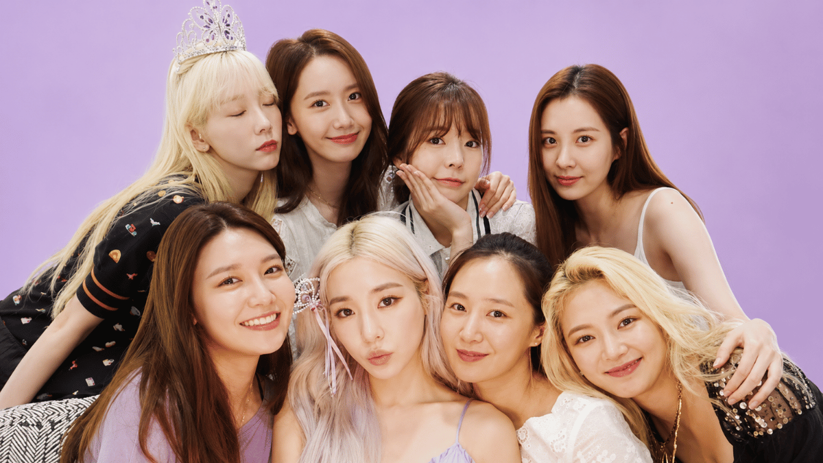 gitls generation members posing in elegant colorful outfits on a pastel purple background