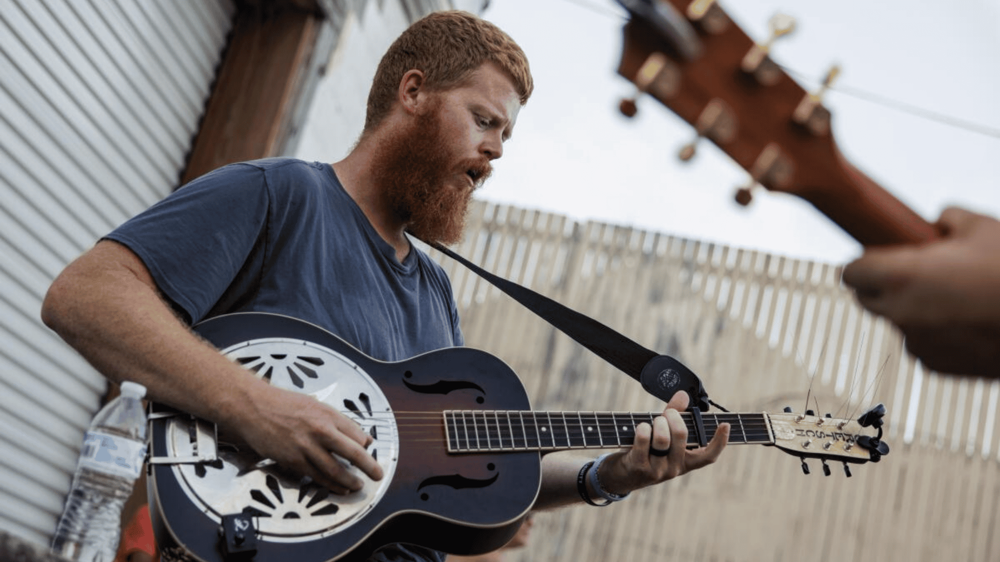 Country singer playing resonator guitar during an outdoor performance