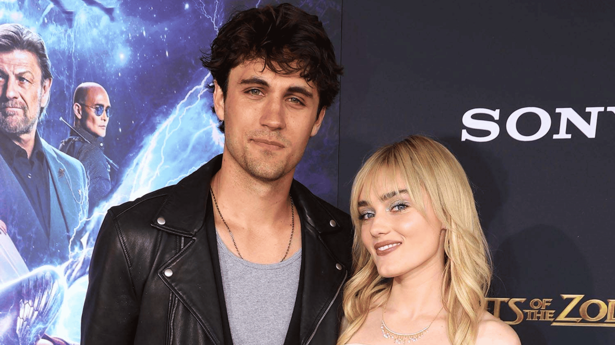 Meg Donnelly and Drake Rodger pose together at a movie premiere, smiling on the red carpet event.