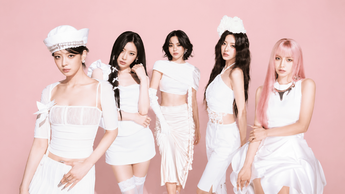 itzy members posing in elegant white outfits on a pastel pink background