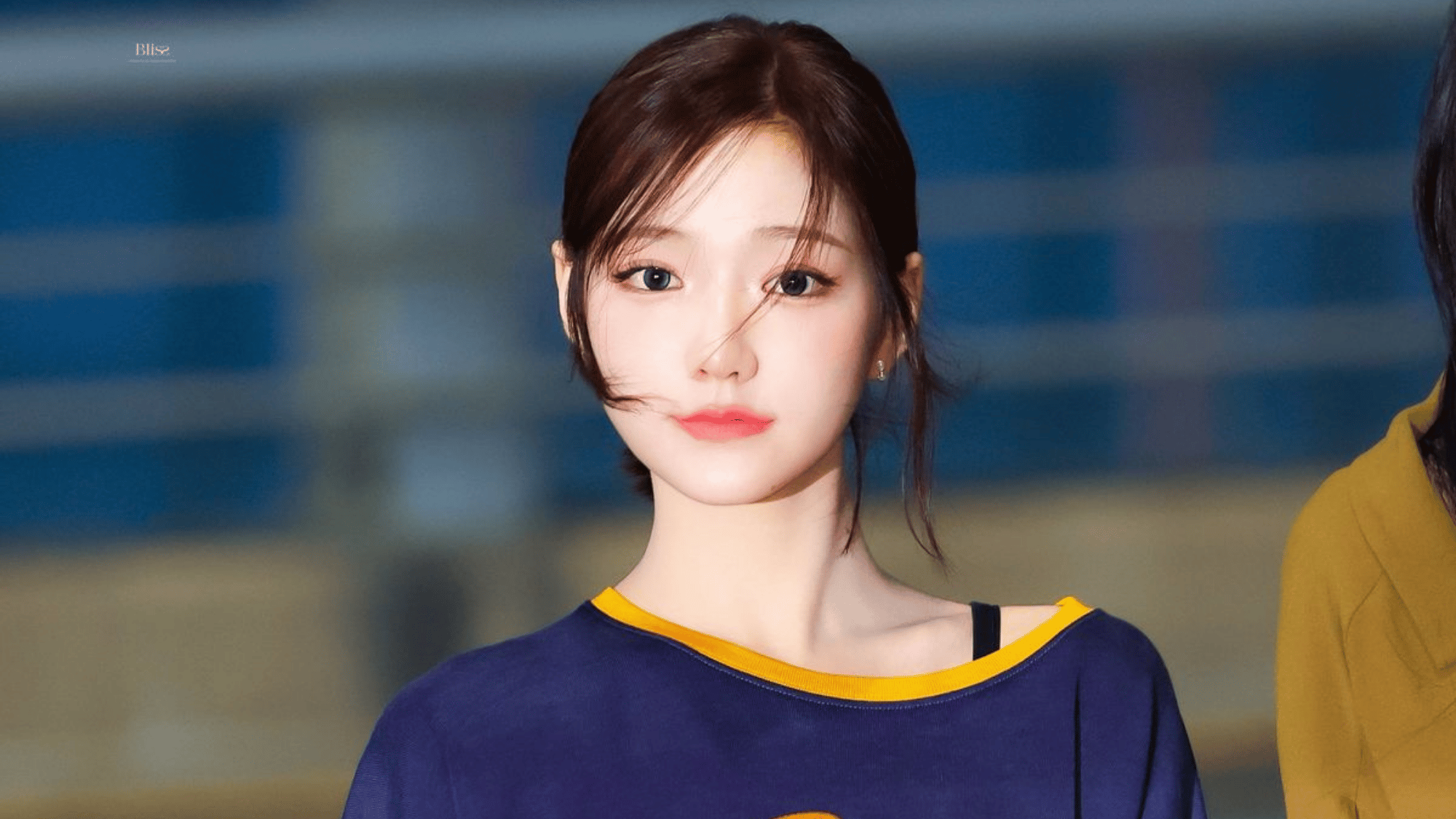 KiiiKiii leader Jiyu in a blue and yellow top with hair pulled back