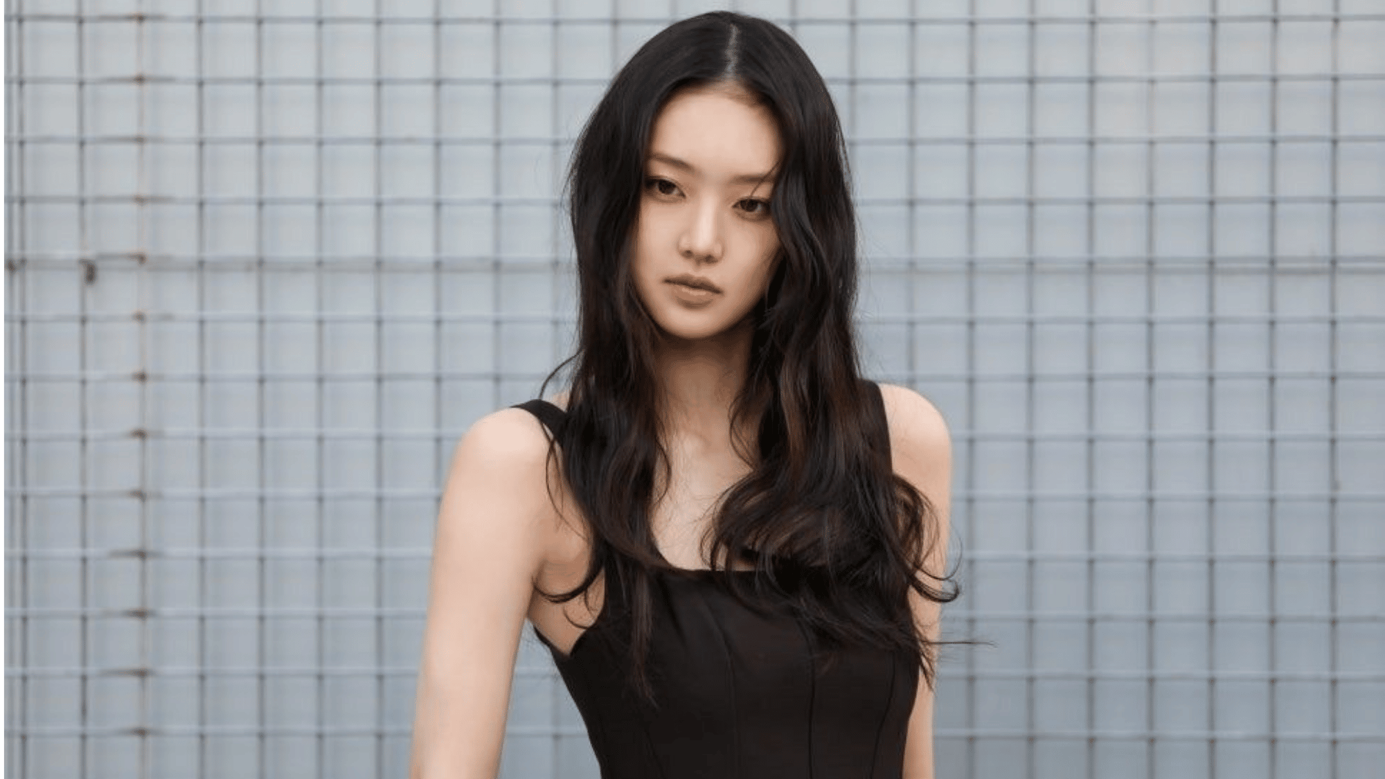 KiiiKiii member Leesol wearing a black tank top with long wavy dark hair